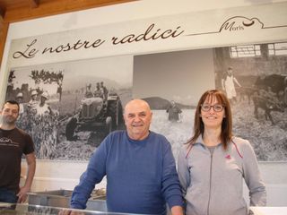 Ivan, Franco ed Elisa nel punto vendita di Caraglio con le foto storiche dell'azienda