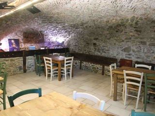 La sala ristorazione dell'agriturismo ricavata nella vecchia stalla con la volta a botte in pietra e la mangiatoia