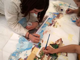 Allieve del Bertoni con l'insegnante Gabriella Messina  all'opera nel disegnare Saluzzo sull'abito da sposa