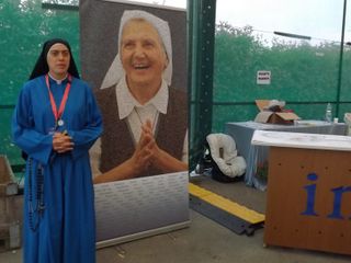 Giovane religiosa davanti alla foto di Madre Elvira