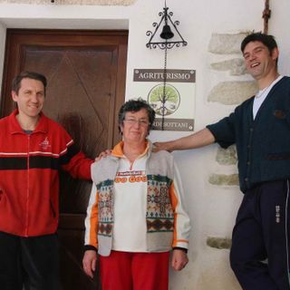 Paolo, mamma Domenica e Claudio davanti all'ingresso dell'agriturismo