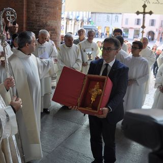 Roberto Cerrato mostra la croce dorata contenente l'ampolla al vescovo albese Marco Brunetti