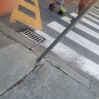 Vettura parcheggiata senza freno a mano abbatte un cartello stradale a Cuneo