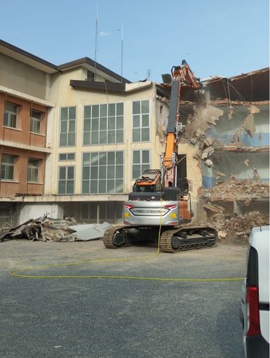 La ruspa in azione per abbattere le vecchie scuole