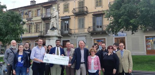 Saluzzo, foto di gruppo davanti al monumento di Silvo Pellico con il simbolico assegno della cifra che contribuirà alla sua pulizia