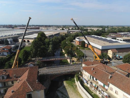L'installazione della nuova passerella ciclopedonale a fianco del ponte sul Mellea di via Alba che sarà abbattuto e poi ricostruito