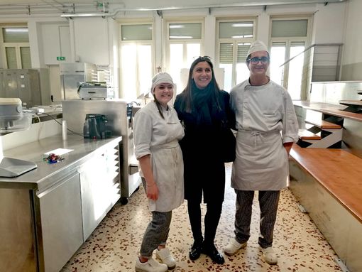Il viceministro posa con due allievi nel laboratorio di pasticceria