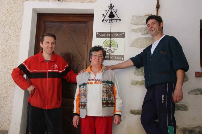 Paolo, mamma Domenica e Claudio davanti all'ingresso dell'agriturismo