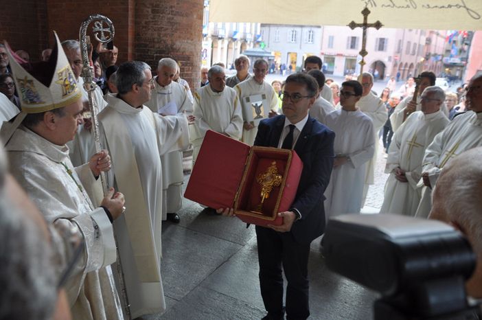Roberto Cerrato mostra la croce dorata contenente l'ampolla al vescovo albese Marco Brunetti