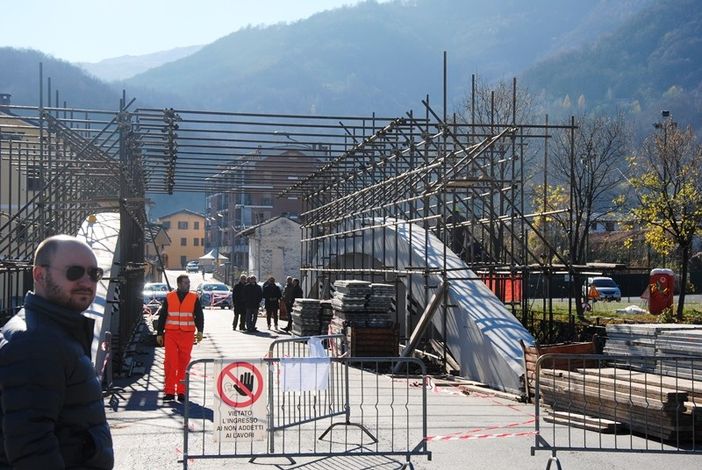 Il vicesindaco Emanuele Vaudano con, sullo sfondo, i massicci lavori sul ponte sul Po di Paesana