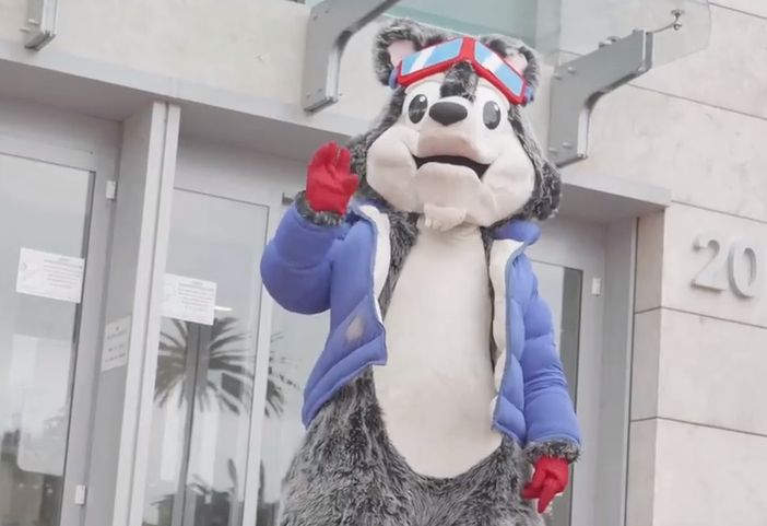 La mascotte di Prato Nevoso, il lupo Asso, davanti alle porte d'ingresso dell'ospedale "Gaslini" di Genova