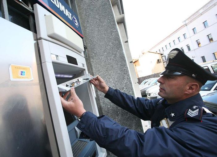 Un carabinieri mostra il bancomat clonato