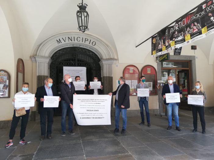 Fossano, nel giorno della riapertura un cartello polemico sul portone del comune: "Basta parole, dal governo ci vogliono fatti concreti"