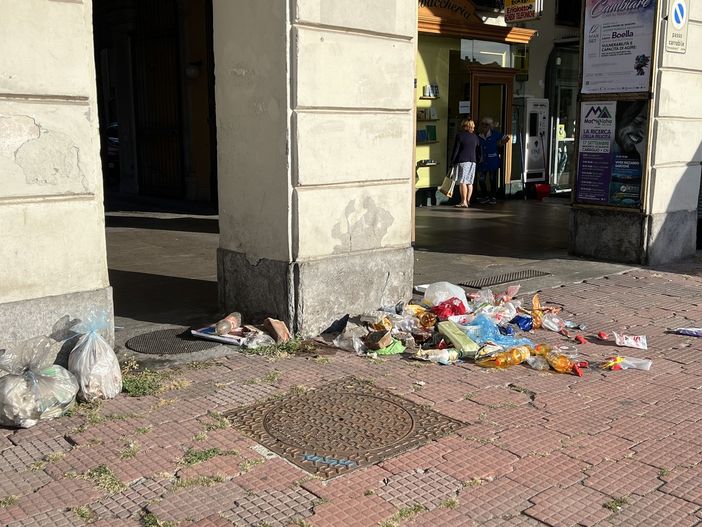 Sacco della plastica divelto e rifiuti sparsi sul marciapiede di piazza Galimberti Sacco della plastica divelto e rifiuti sparsi sul marciapiede di piazza Galimberti