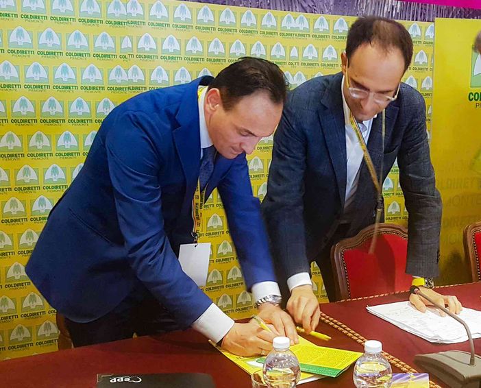 Il presidente Alberto Cirio firma il manifesto di Coldiretti con le dieci priorità per l'agricoltura piemontese sotto gli occhi attenti del delegato confederale di Cuneo, Roberto Moncalvo