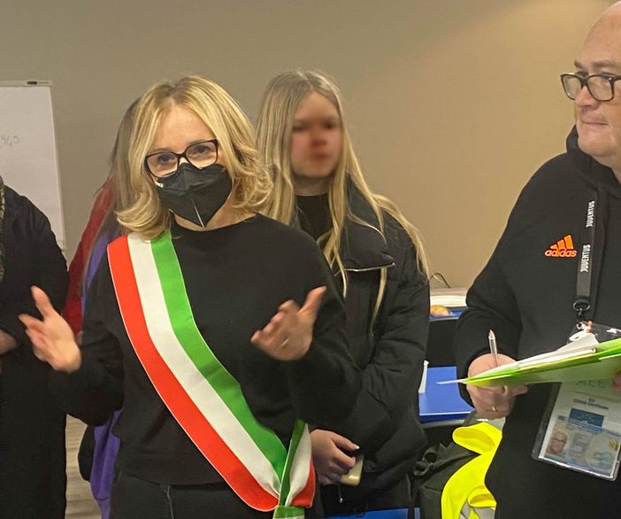 In primo piano il sindaco di La Morra Marialuisa Ascheri durante il momento di accoglienza dei profughi all'Hotel Santa Maria