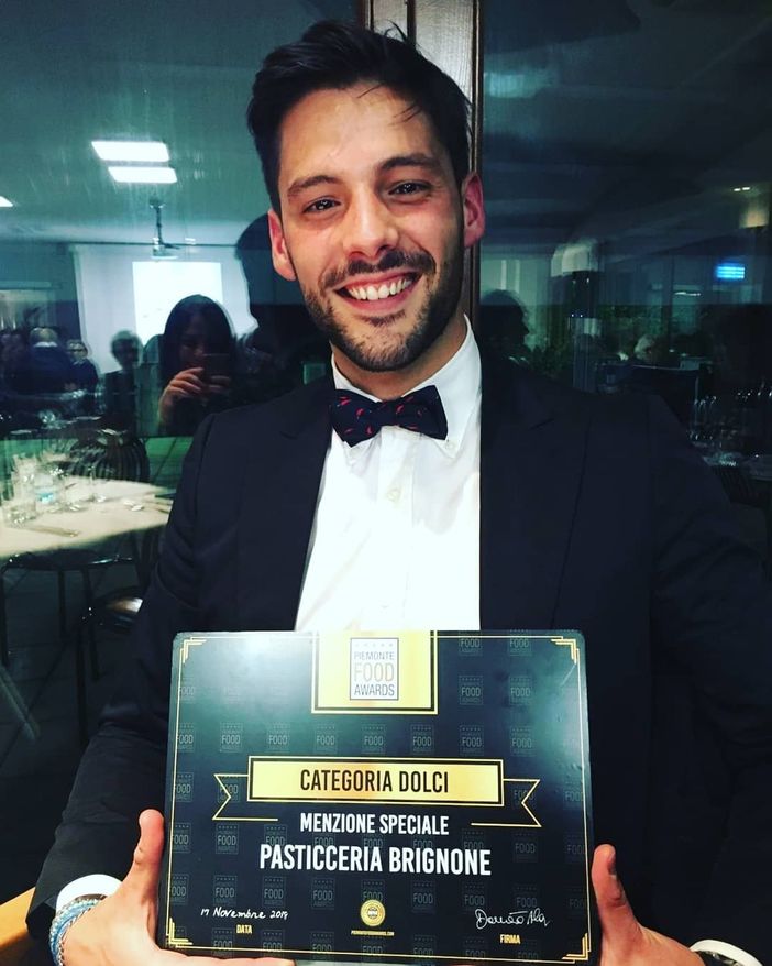 Umberto Brignone mostra la targa menzione d'onore  Piemonte Food Awards alla pasticceria di Dronero