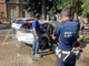 La Polizia Locale di fronte all'auto distrutta