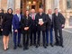 Nicola Cotti con il libro su Chiaffredo Bergia assieme al collega Stefano De Carolis, gli amministratori comunali di Paesana e i familiari, a Roma davanti al Palazzo Madama