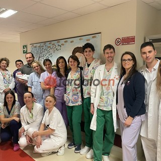 La piccola con i genitori e il personale del Regina Montis Regalis