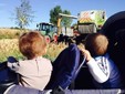 I bambini assistono alla trebbiatura del mais