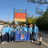 I giocatori dell'Over 50 Football Club Provincia Granda con la bandiera della Provincia per le strade di Manchester