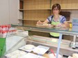 Arianna prepara gli assaggi del formaggio nel punto vendita di Borgo San Giuseppe