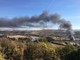 A fuoco un capannone a Farigliano: colonna di fumo nero visibile da grande distanza